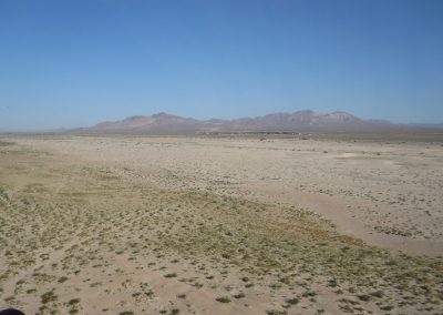 Large Open Dirt Plane Birdseye View With Large Mountain Range In Background