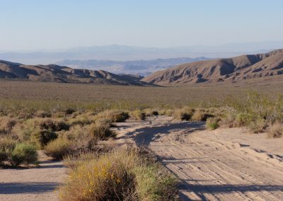 Desert Road Through Mountain Range In Mojave Desert
