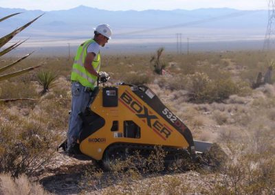 Construction Worker Using Boxer Car To Flatten The Ground Around Empty Desert Area